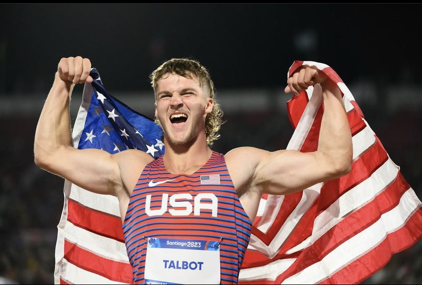 Ryan Talbot flexing with Team USA flag during international competition